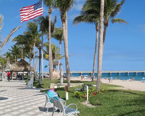 Older person sitting on bench at Deerfield Beach.